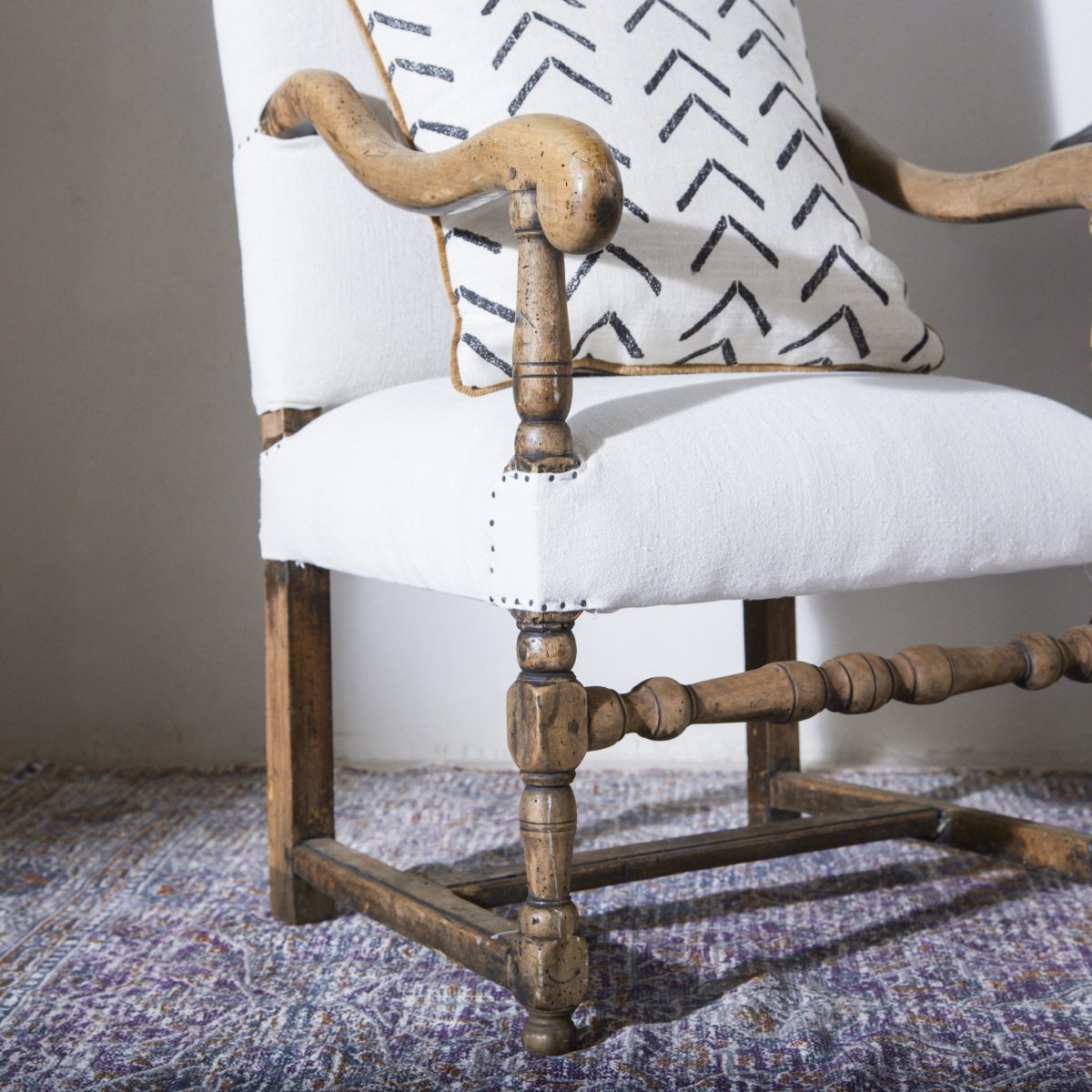 Butaca antigua de madera tapizada en lino beige